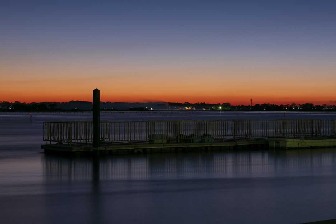 弁天島海浜公園から撮影した夕暮れ時の鳥居の写真